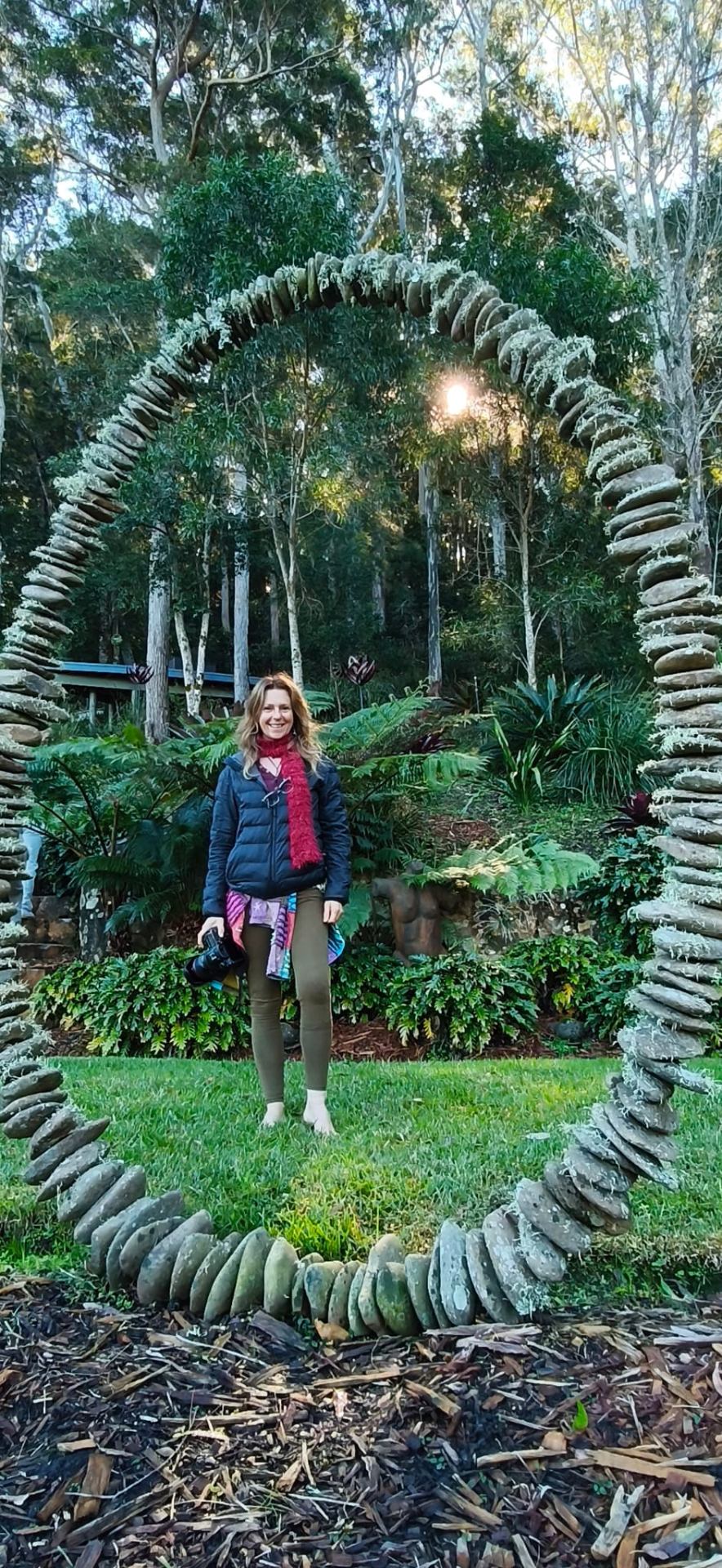 Guest standing within the stone circle arch sculpture in the gardens