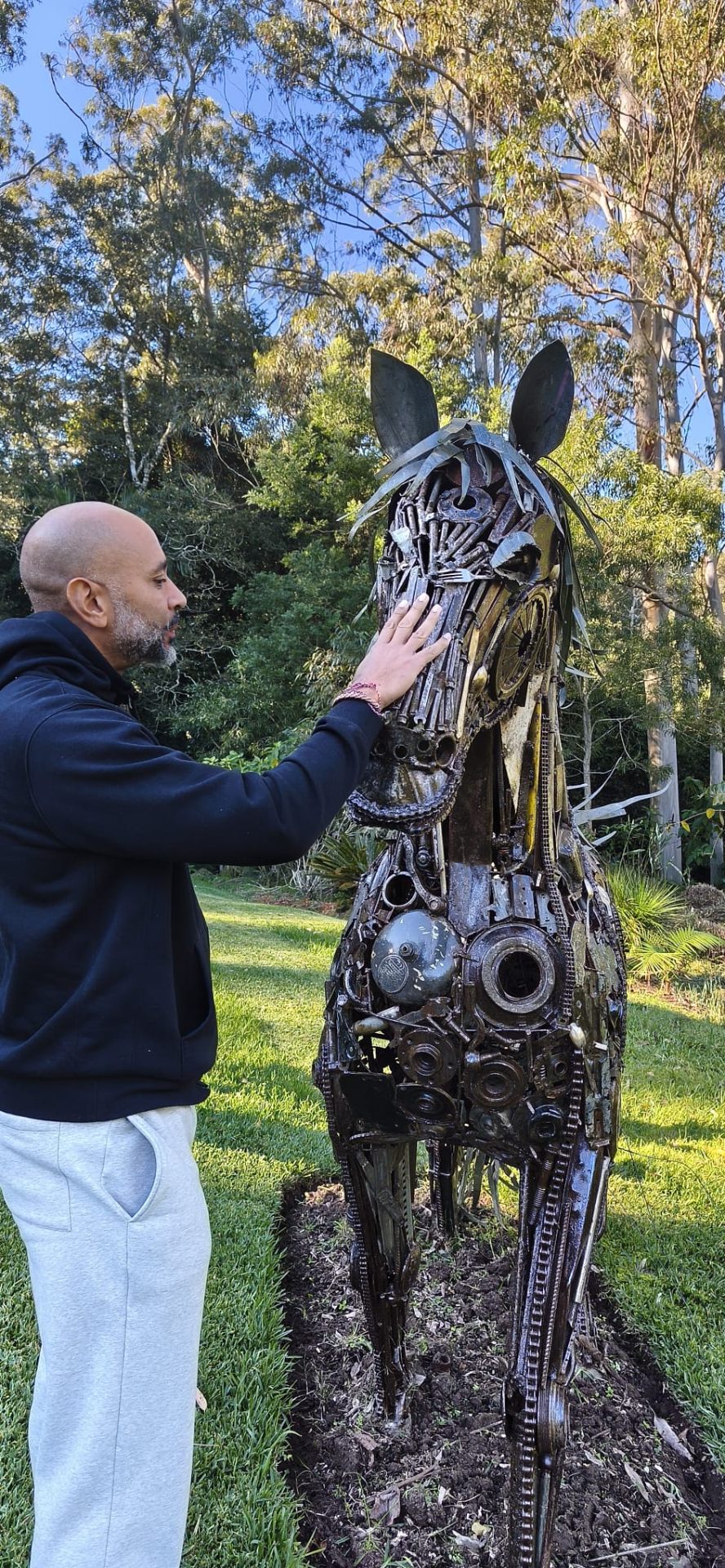 Guest connecting with the metal horse sculpture in the gardens