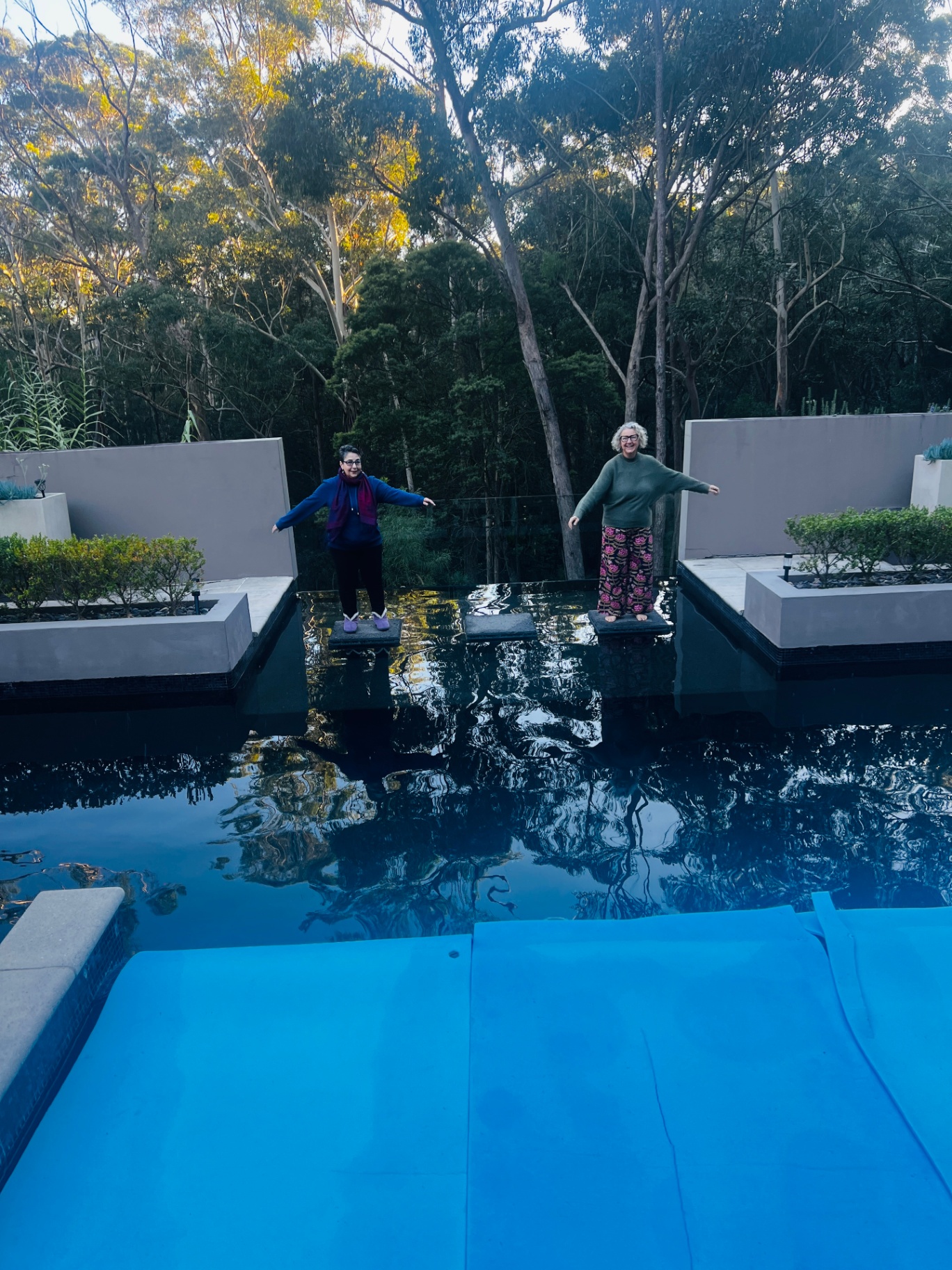 Guests balancing on stepping stones across the reflection pool